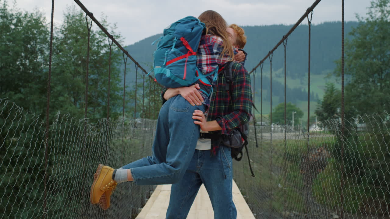una pareja de mochileros abrazándose en las montañas, viajeros divirtiéndose afuera.