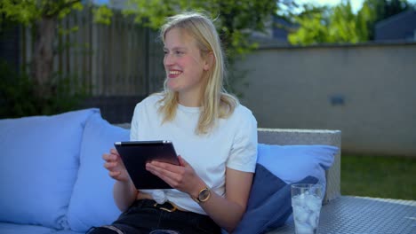 girl drawing on tablet outside on a lounge set