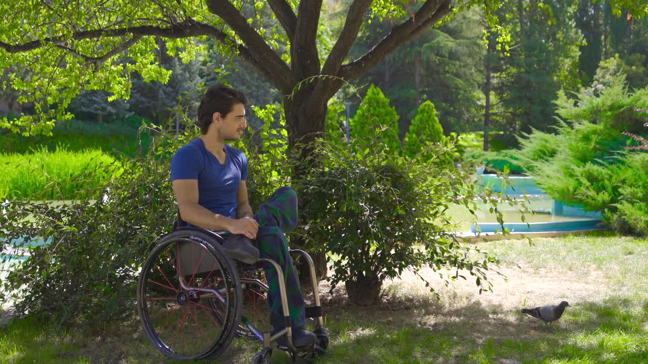 Young disabled person sitting in wheelchair outdoors.