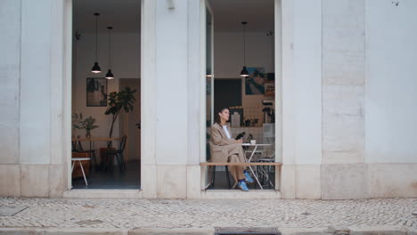 woman resting street cafeteria sitting at small table alone. young lady writing