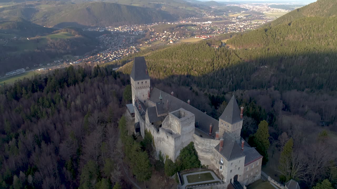 tiro de dron de un castillo en una montaña que revela un hermoso paisaje, volando hacia atrás mientras se inclina hacia arriba, 4k uhd