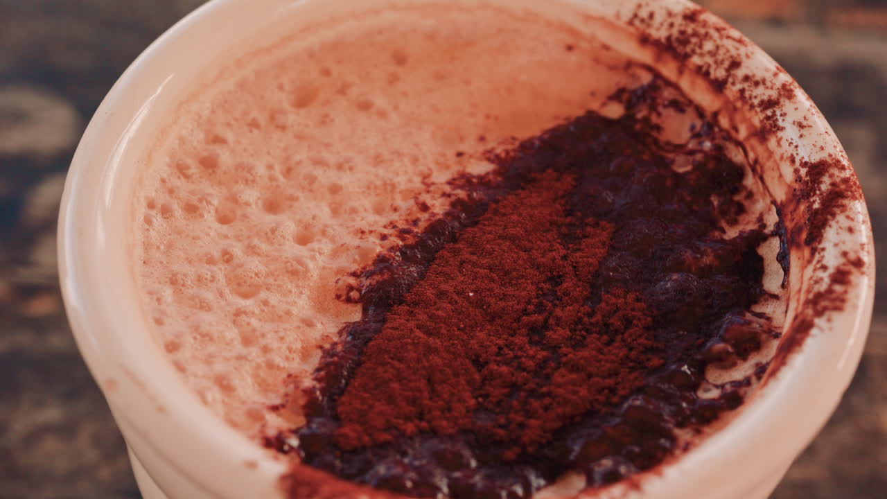 Close up of a rich hot chocolate or coffee surface sprinkled with cocoa powder
