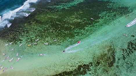 vista aérea de drones de pequeños barcos que aceleran para llegar a una pequeña isla tropical remota en el océano