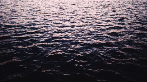 Olas-Y-Agua-Reflejada-De-Un-Lago-Al-Atardecer