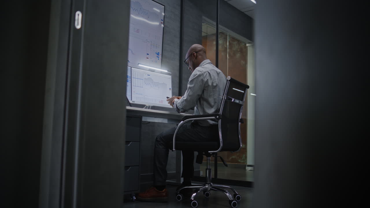 Happy Stock Trader Monitoring Real-Time Stocks on Computer, Having Phone Call, Celebrating Winning Trading Deal. Excited African American Investment Agent Making Profitable Investments. Vertical Shot.