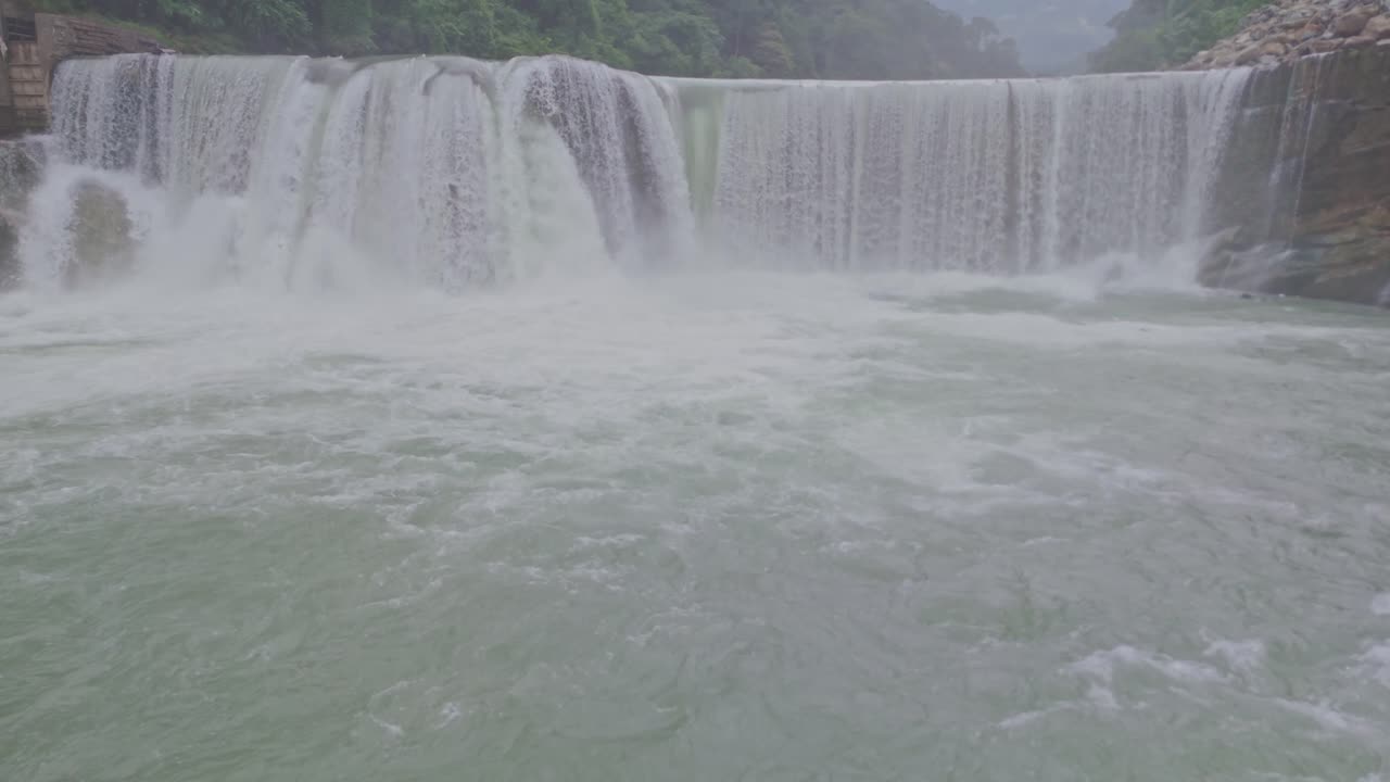 A breathtaking aerial view of a beautiful waterfall cascading through lush green mountains, showcasing the untouched beauty of nature, flowing water, and serene landscape scenery