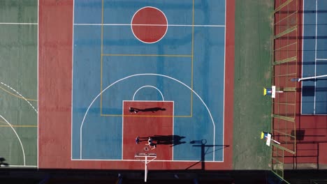 aerial top-down view directly above amateur basketball court with players