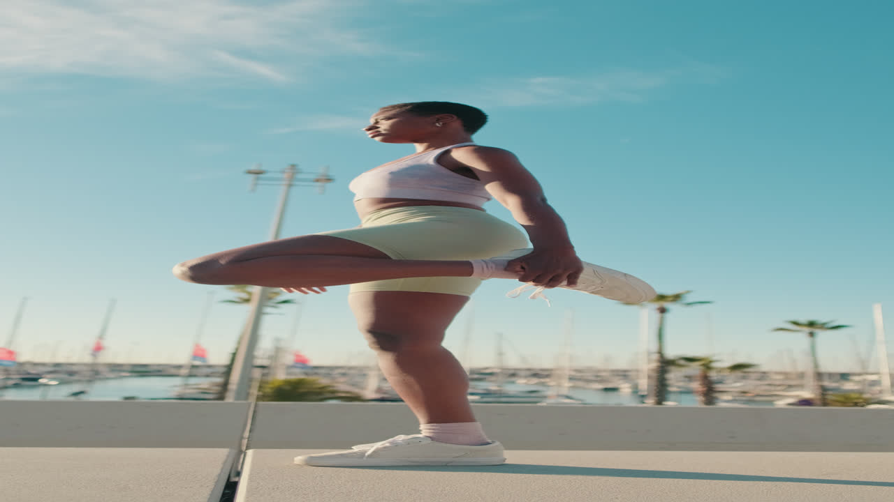 Young Woman Stretching Leg Outdoors at Marina
