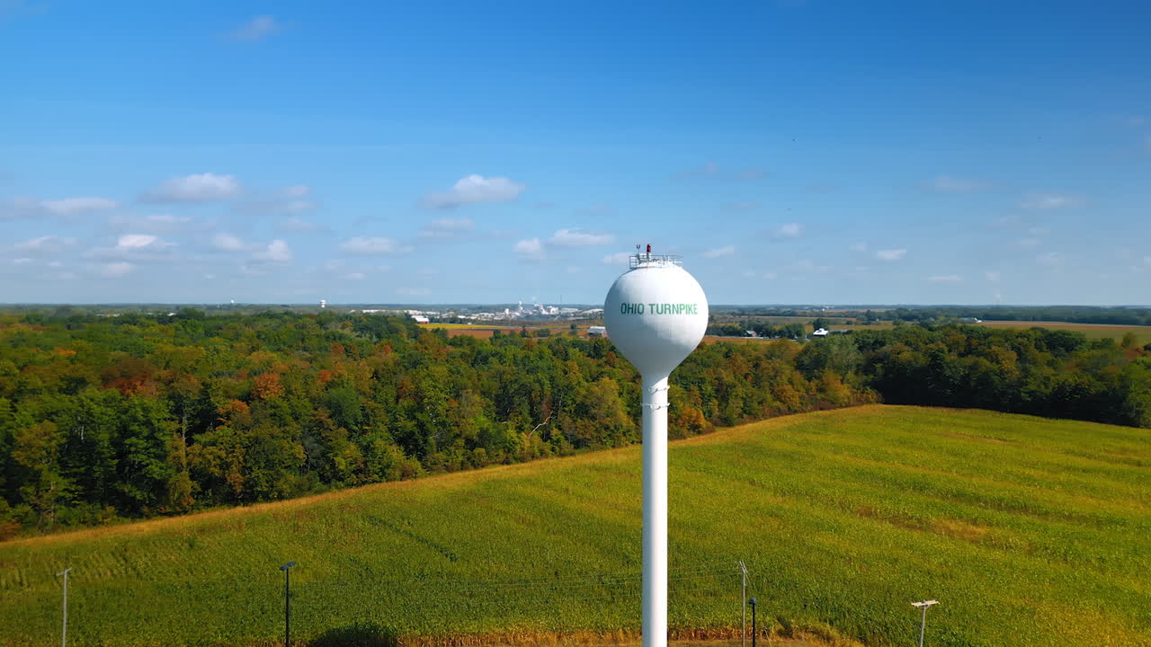 Chicago, USA, 29 June 2025: Water tower with a sign Ohio Turnpike. Beautiful green field and forest at backdrop. Aerial view