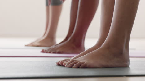 Cerrar-Los-Pies-Clase-De-Yoga-Mujeres-Estirándose-Practicando-La-Pose-De-Media-Curvatura-Hacia-Adelante-Disfrutando-Del-Entrenamiento-Del-Gimnasio