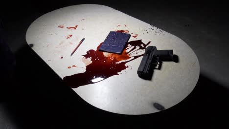 sangre, pistola y diario sobre la mesa