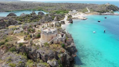 tugboat beach in curacao with clear turquoise waters and rocky coastline, aerial view