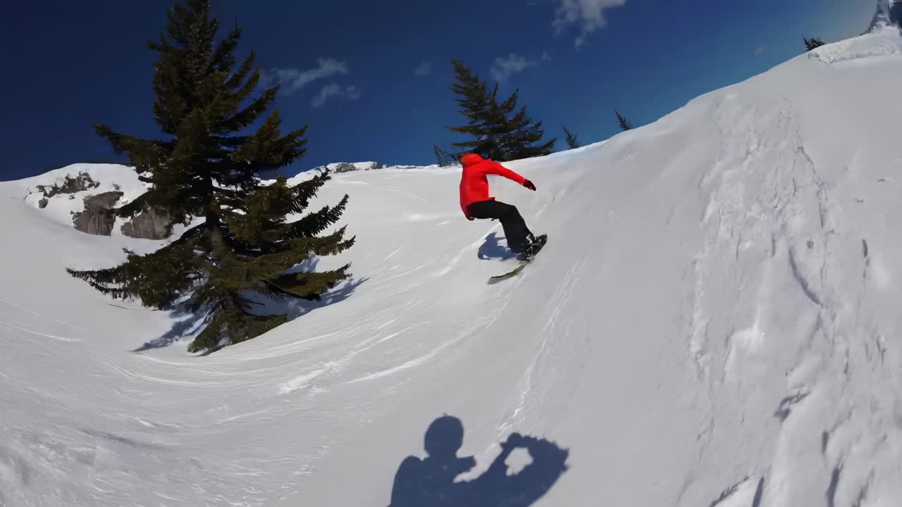 POV video of a snowboarder in a red jacket carving down a snowy slope, with a fisheye lens capturing