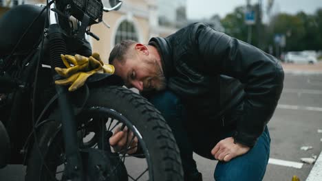 man fixing a motorcycle on the street