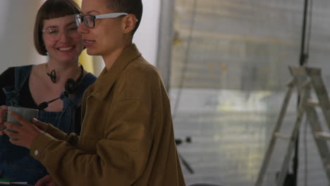 female film director and assistant watching actor on monitor shooting movie or video scene in studio shot in real time