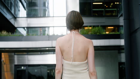 rear view of elegant woman in sunglases looking at camera