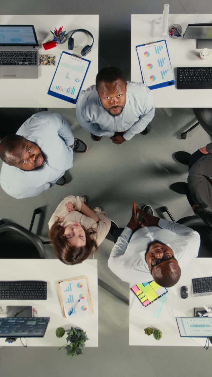 Vertical Video Top down view of diverse colleagues working in modern office