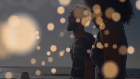 animation of spots over diverse couple at beach