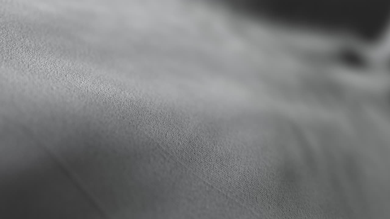 Minimální textura bílé látky s jemnou animací plynoucích vln.