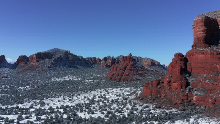 Aerial Pan of Bell Rock and Courthouse Butte, Village of Oak Creek, Sedona Arizona - After a snowfall