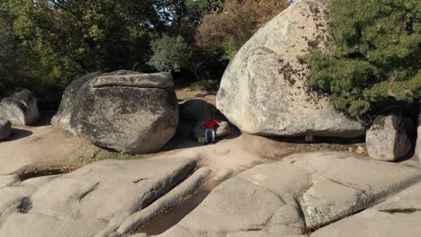 drone view of a man sitting at begliktash which is an ancient ruin near the city of primorsko, bulgaria