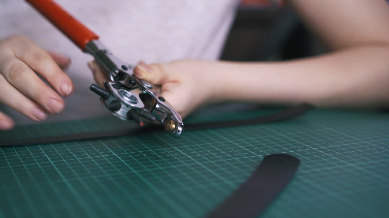 Designer professionista prepara una pinza perforatrice per cinture in pelle