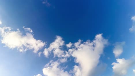 this is a 4k video of a timelapse of clouds passing by in fast motion set upon a beautiful blue sky