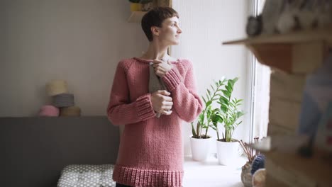 woman holding in hands knitted clothes for baby. handmade clothes for children