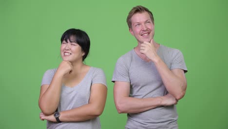 Young happy multi-ethnic couple thinking together