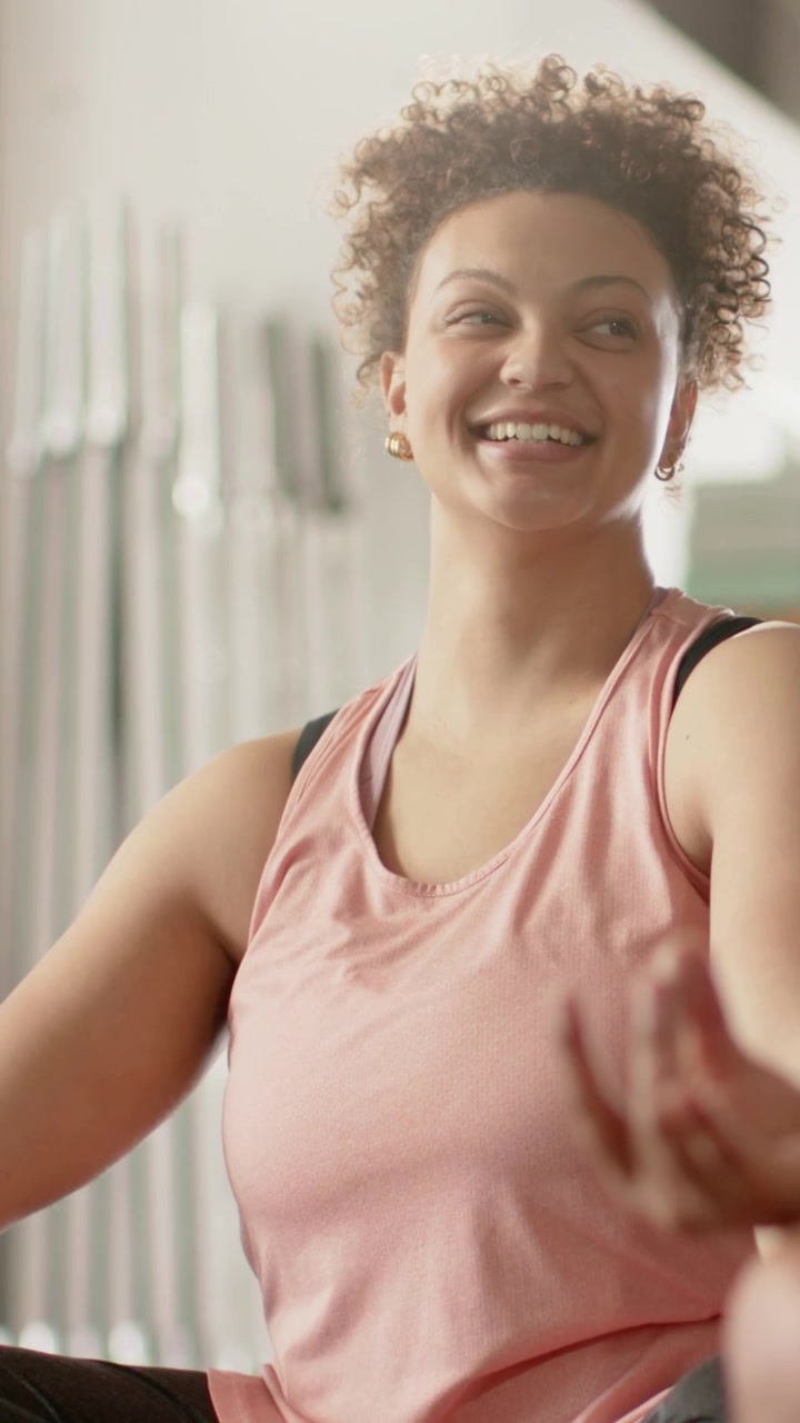Vídeo vertical: Mulher abrindo os olhos e levantando a cabeça após uma pausa em estúdio com Gyan mudra, blusa rosa