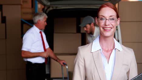 delivery driver packing his van with manager smiling at camera