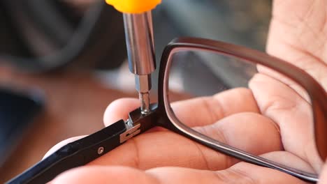 repairing glasses with a screwdriver