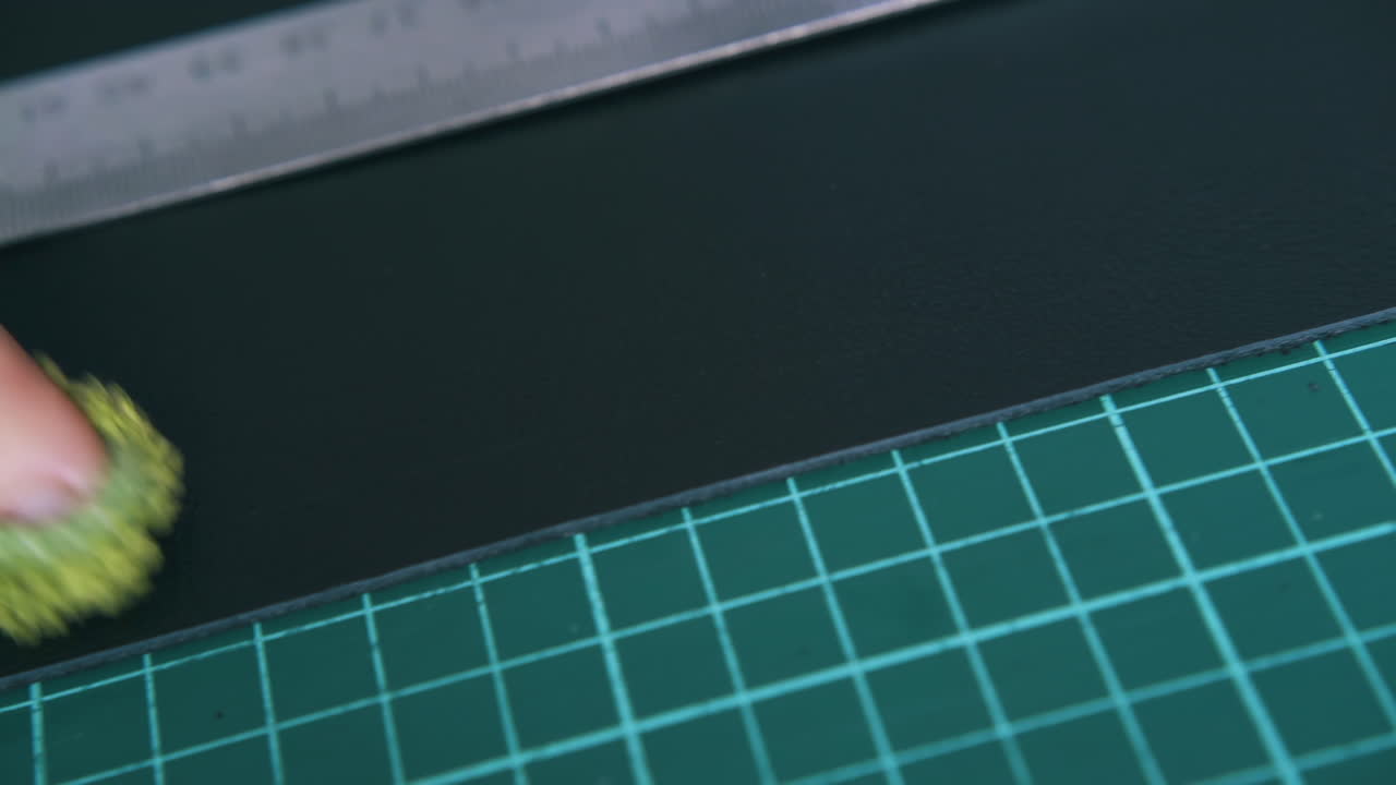 человек вручную очищает черную кожаную ткань мокрым полотенцем