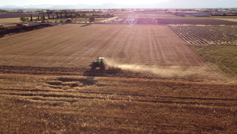 combine harvester harvesting wheat grain in agriculture cereal farming field aerial view
