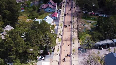 people enjoy sunny day by walking on basanavicius street in palanga, aerial