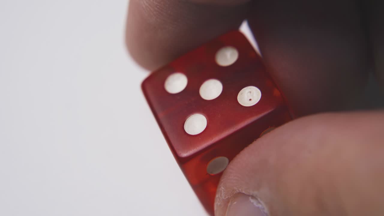 el joven gira los dados con símbolos cinco sobre fondo blanco