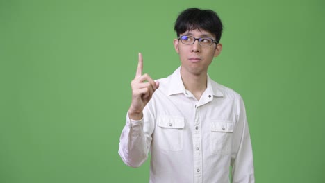 young asian businessman pointing up and thinking