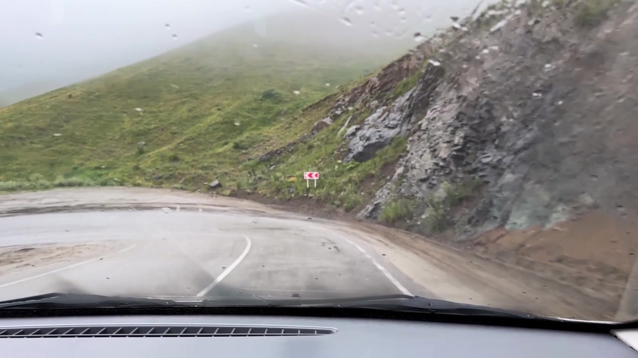 Guida su strada di montagna, destinazione di viaggio Armenia Georgia, gioioso viaggio su strada in prato di montagna, avventura di viaggio panoramica, paesaggio suggestivo nuvoloso e umido, percorso autostradale, turismo all'aperto, veicolo in movimento