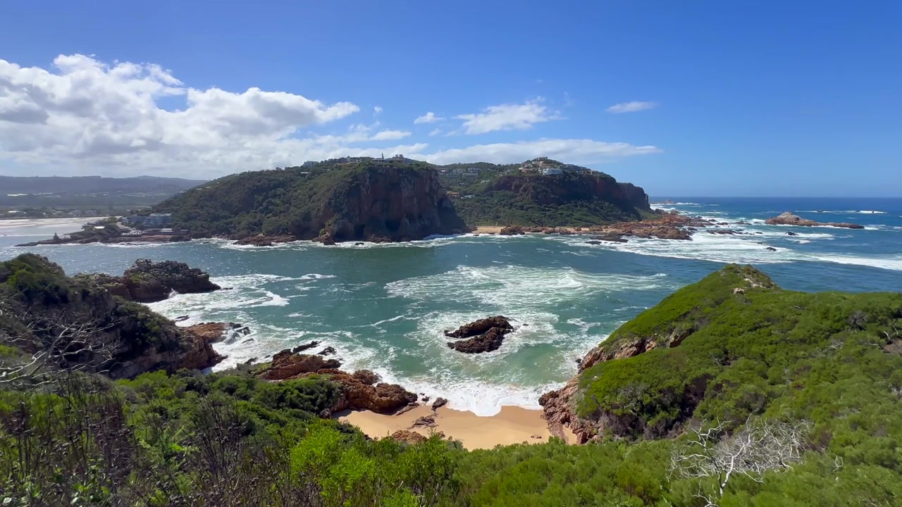 Paesaggio costiero della Laguna di Knysna con scogliere rocciose e acque blu. Sudafrica