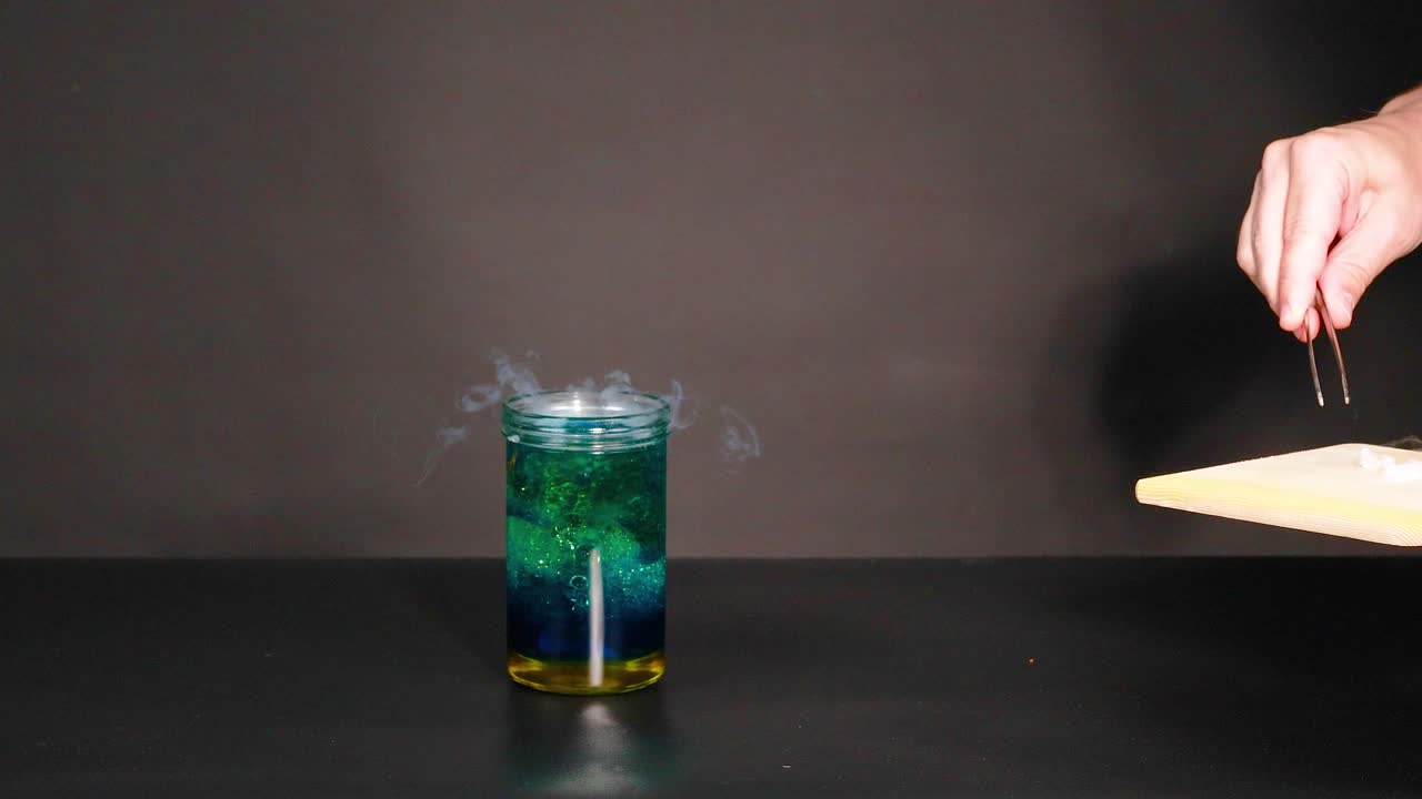 un vaso con hielo seco crea una reacción de humo, mostrando un experimento químico en un entorno controlado