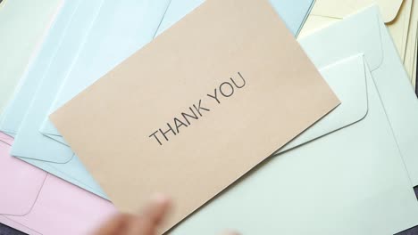 thank you message and envelope on wooden table