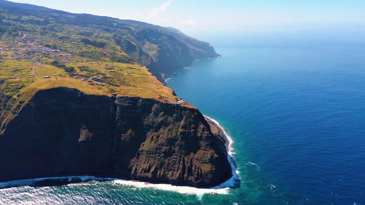 Mountainous shore of the Madeira Islands, Portugal on sunny day. Aerial scenery of the waterscape of the Atlantic Ocean.