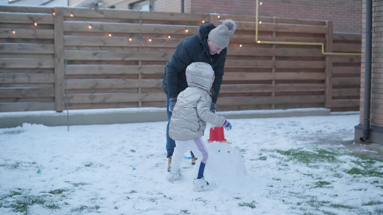 할아버지와 손녀가 눈 속에서 재미를 느끼고 있습니다.