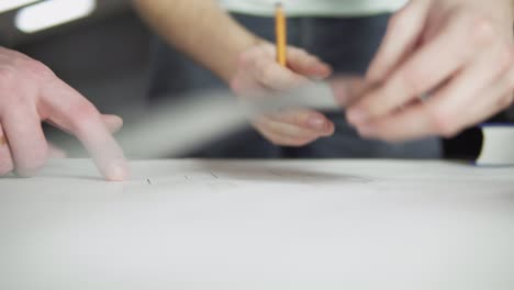 Close-up-view-of-an-architect-drawing-and-measuring-construction-plan-in-the-office.-Shot-in-4k