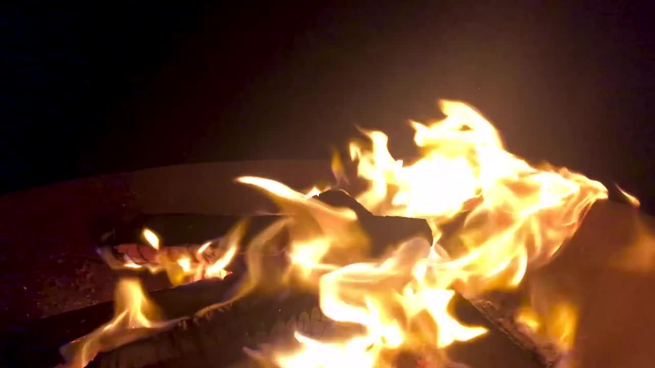 Slow motion flames burning in fire bowl at night, close up static shot