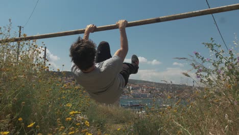 Young-fit-man-training-front-lever-progressions-outdoors-on-bar-street-workout