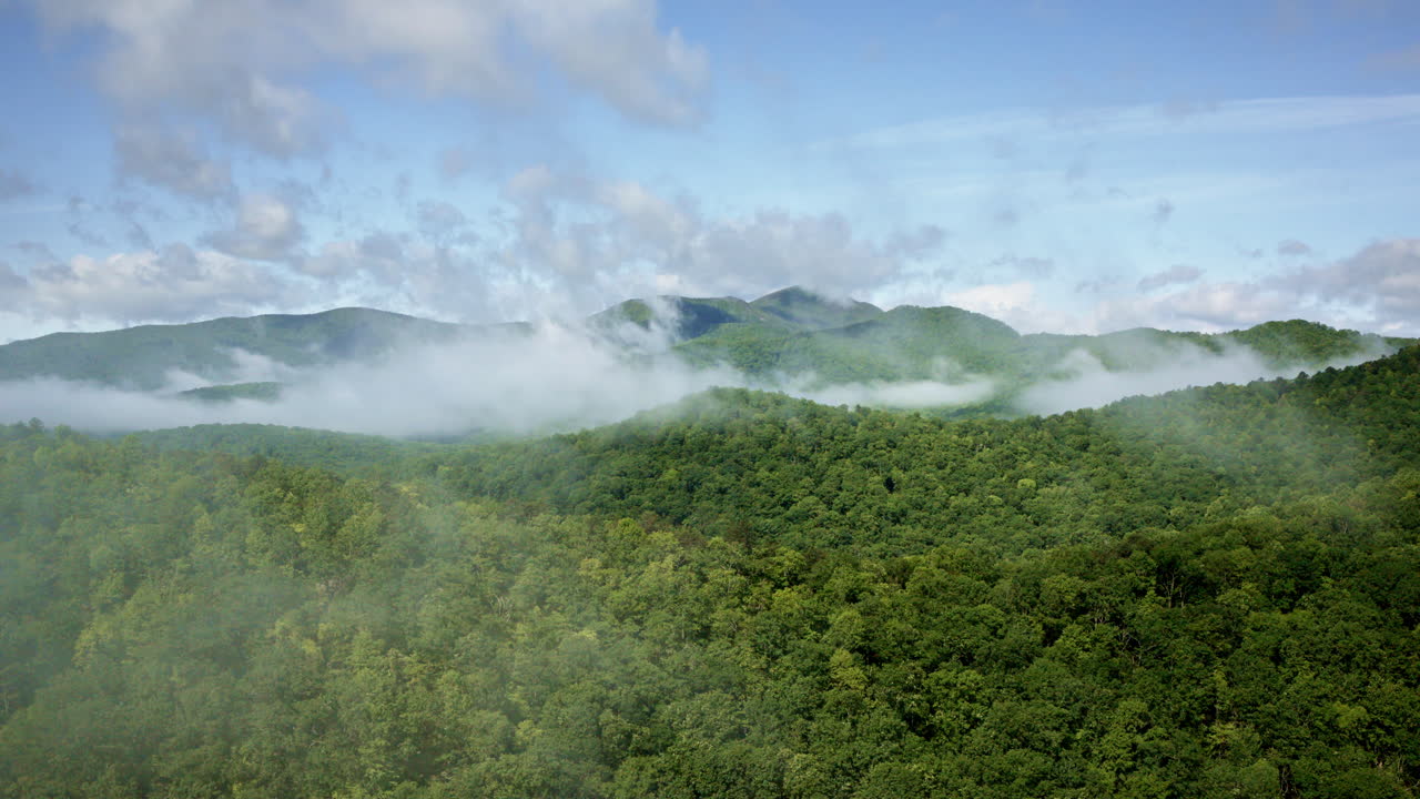 High-altitude drone view of mist swirling over the Smoky Mountains in the United States