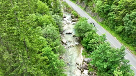 Drone-Aéreo-Sobre-La-Carretera-Con-Un-Automóvil-En-Las-Montañas-Del-Bosque-Verde-Pintoresco-Valle-Del-Río-Logar-Eslovenia-Viajes-Y-Turismo