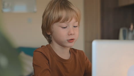 Niño-Pequeño-Que-Tiene-Clase-En-Línea-Con-Una-Computadora-Portátil-En-Casa,-Madre-Ayudando