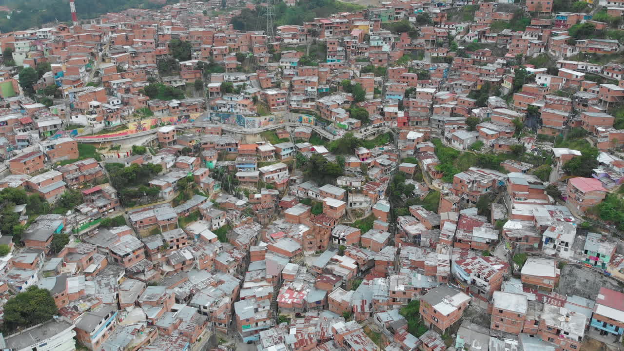 paisaje urbano de coloridas casas de ladrillo en la comuna 13, barrio marginal de pobreza en medellín colombia - toma aérea de drones